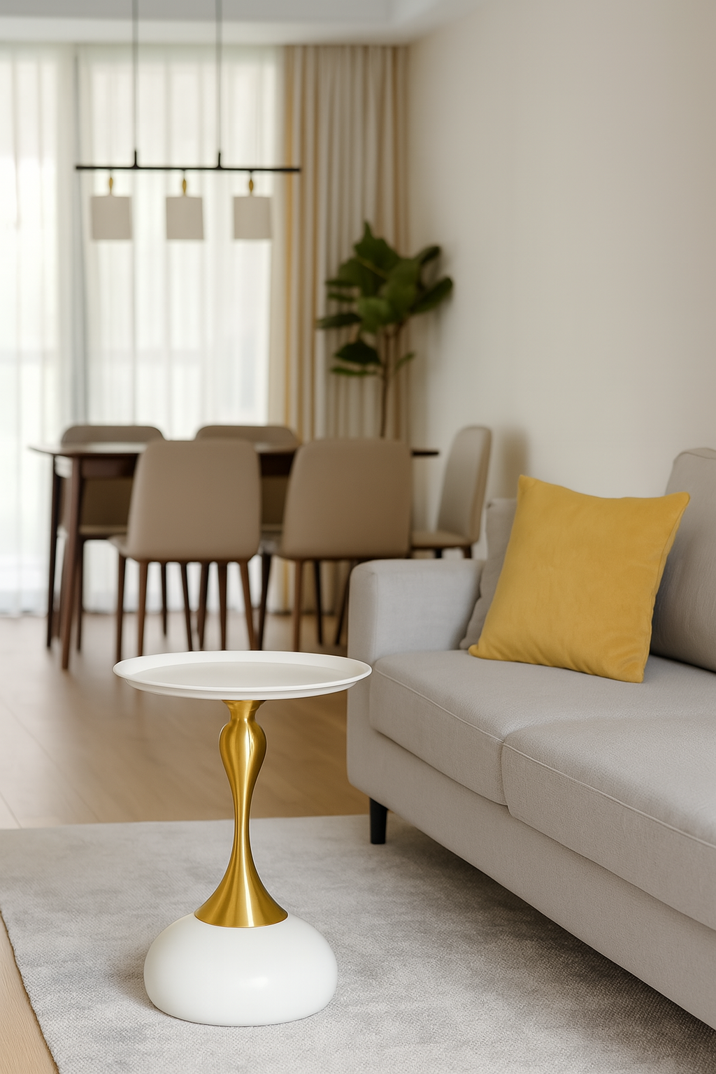 Modern living room with a white and gold side table, beige sofa, and dining area.
