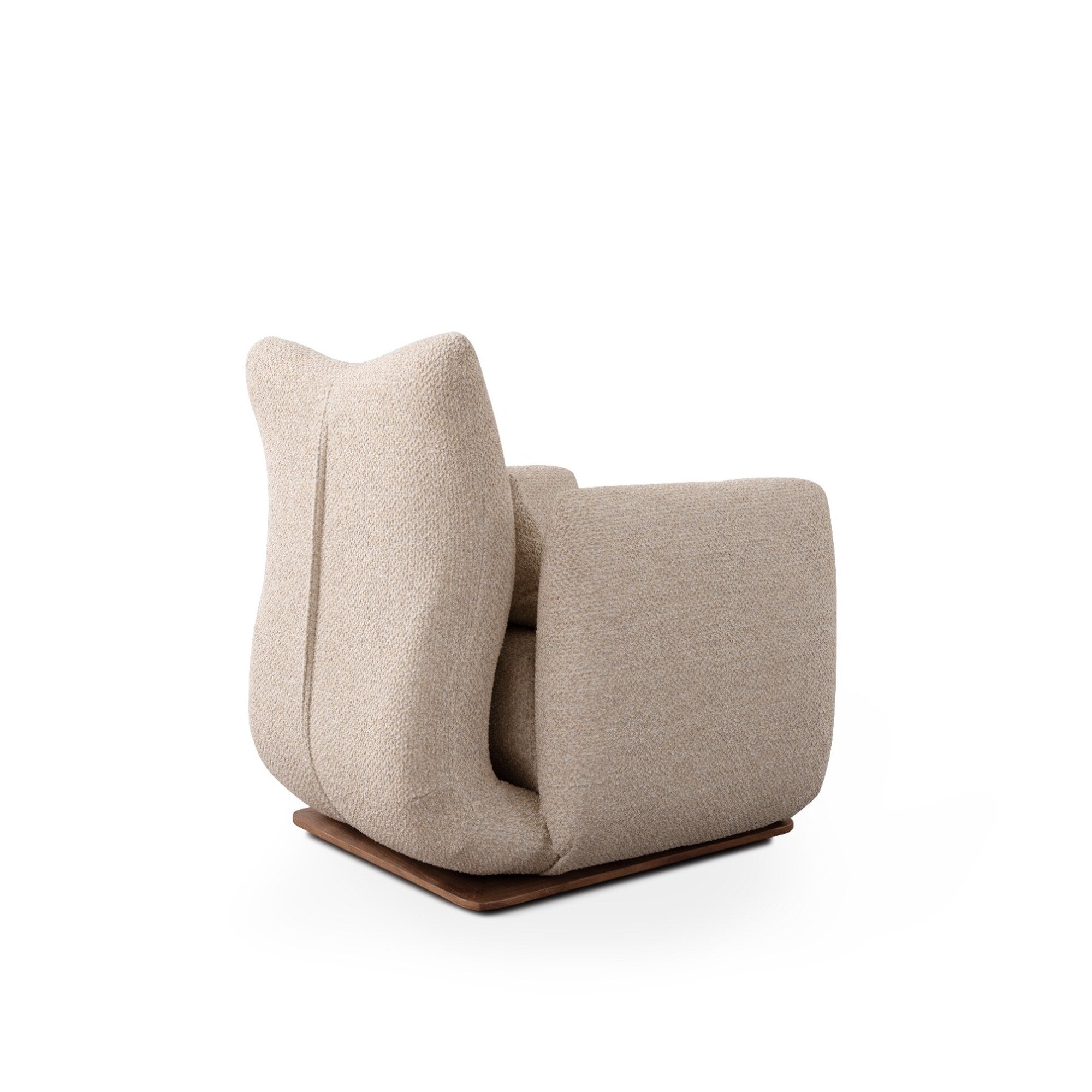 A modern low-profile armchair upholstered in a textured beige fabric, featuring a sculptural curved back and seat, resting on a dark brown wooden base against a solid white background.