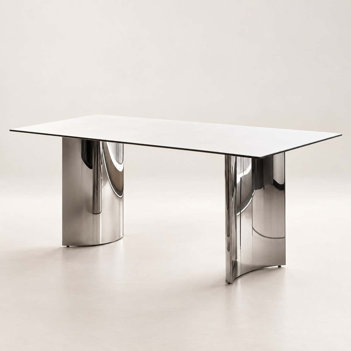 White ceramic dining table with two reflective chrome-tone pedestals on a neutral background.