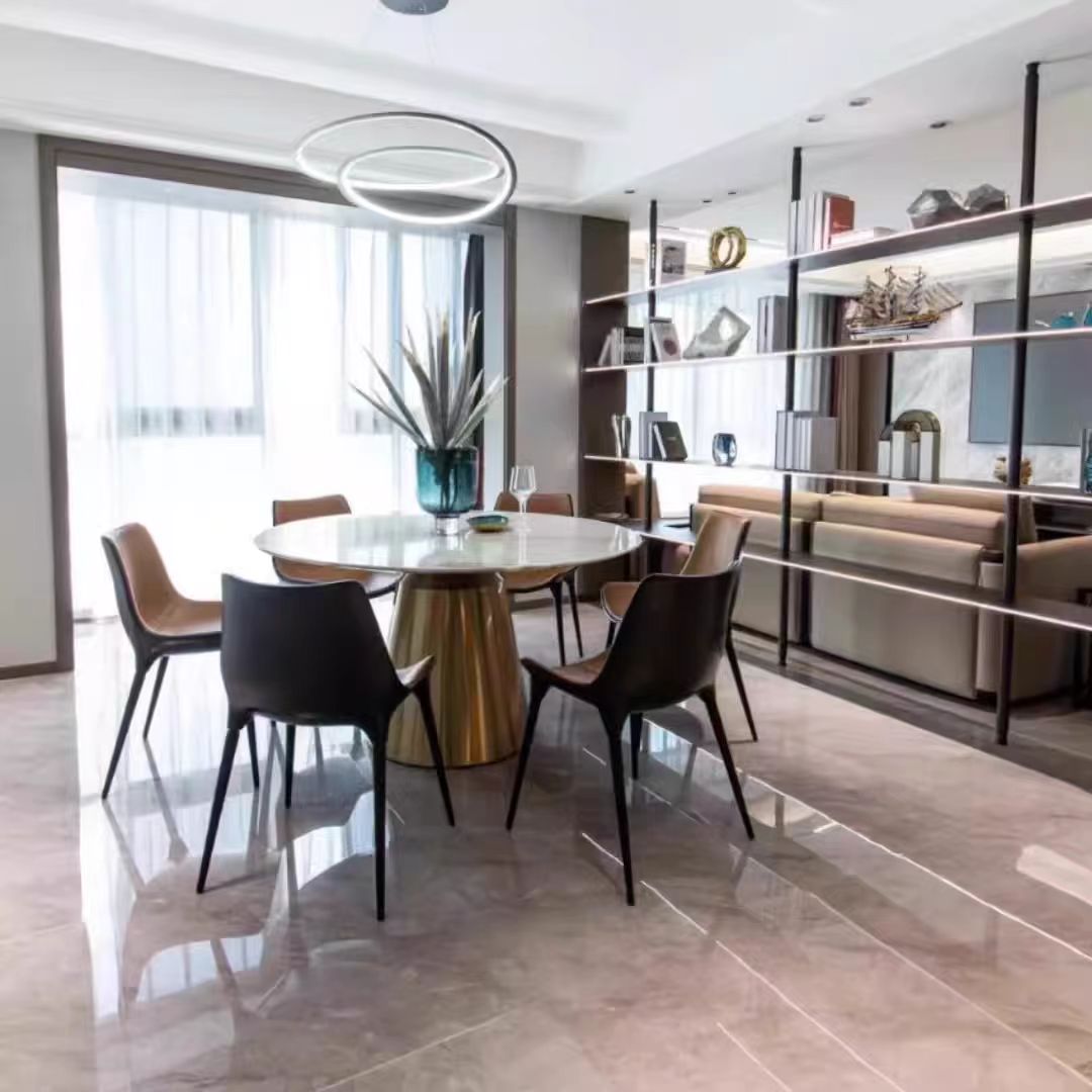 Modern dining room with round table and chairs in a well-lit room.