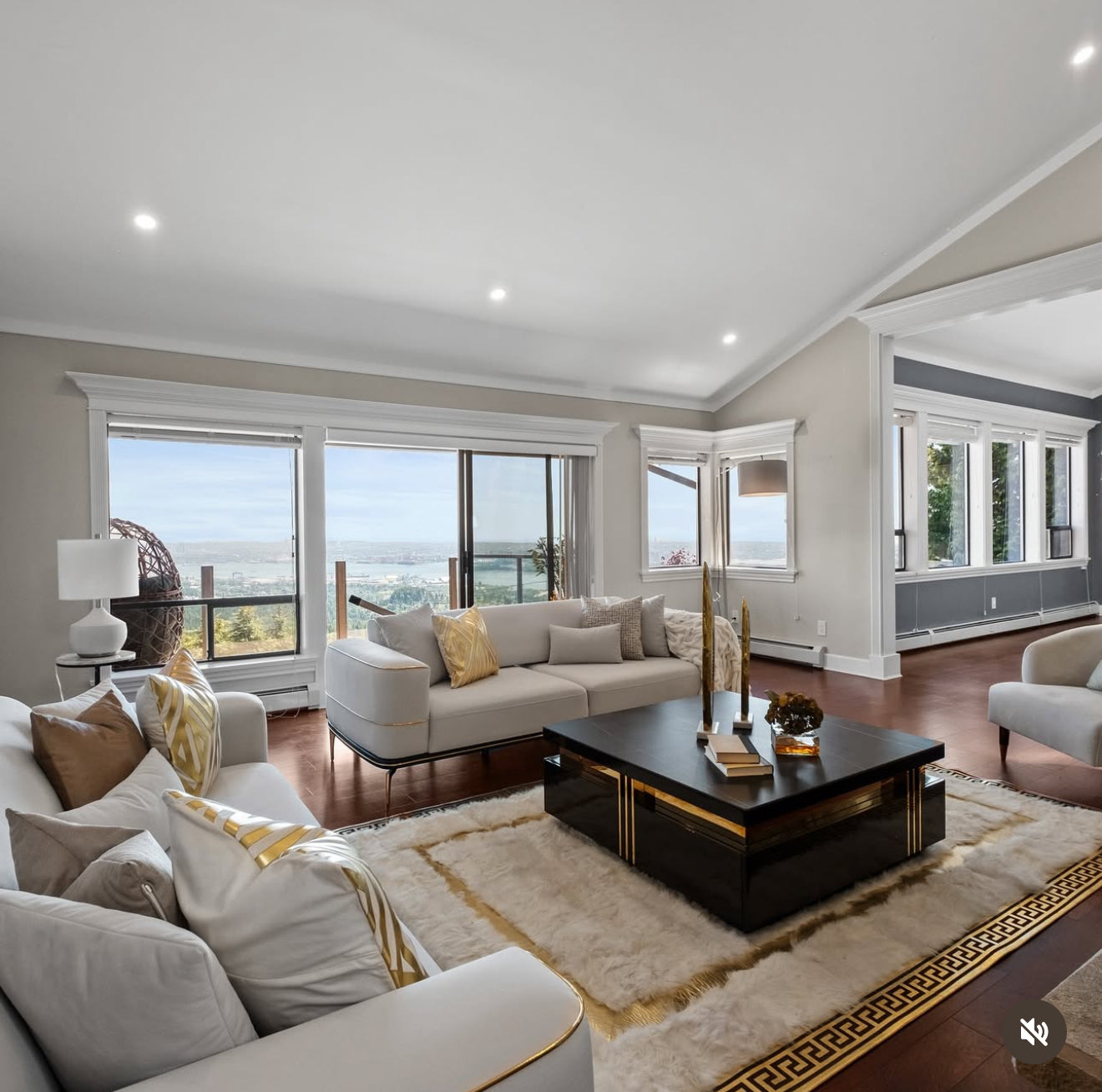 Modern living room with large windows, gray sofa, and wooden coffee table.