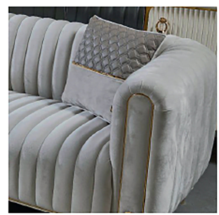 Gray tufted sofa with decorative pillow against a neutral background