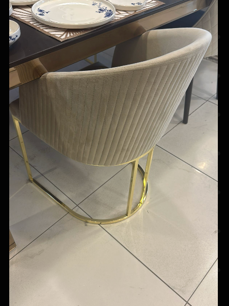 Beige chair with gold legs on a tiled floor