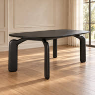 Avero black ceramic dining table with sculptural black legs in a sunlit dining room
