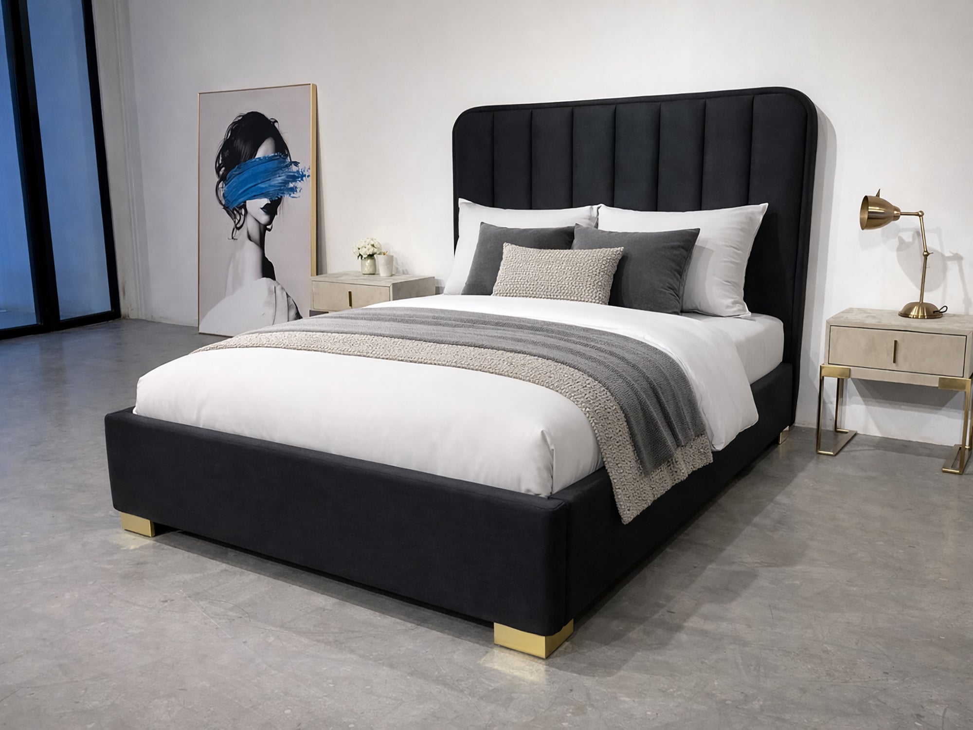 Modern bedroom with a black upholstered bed, white bedding, and decorative pillows.