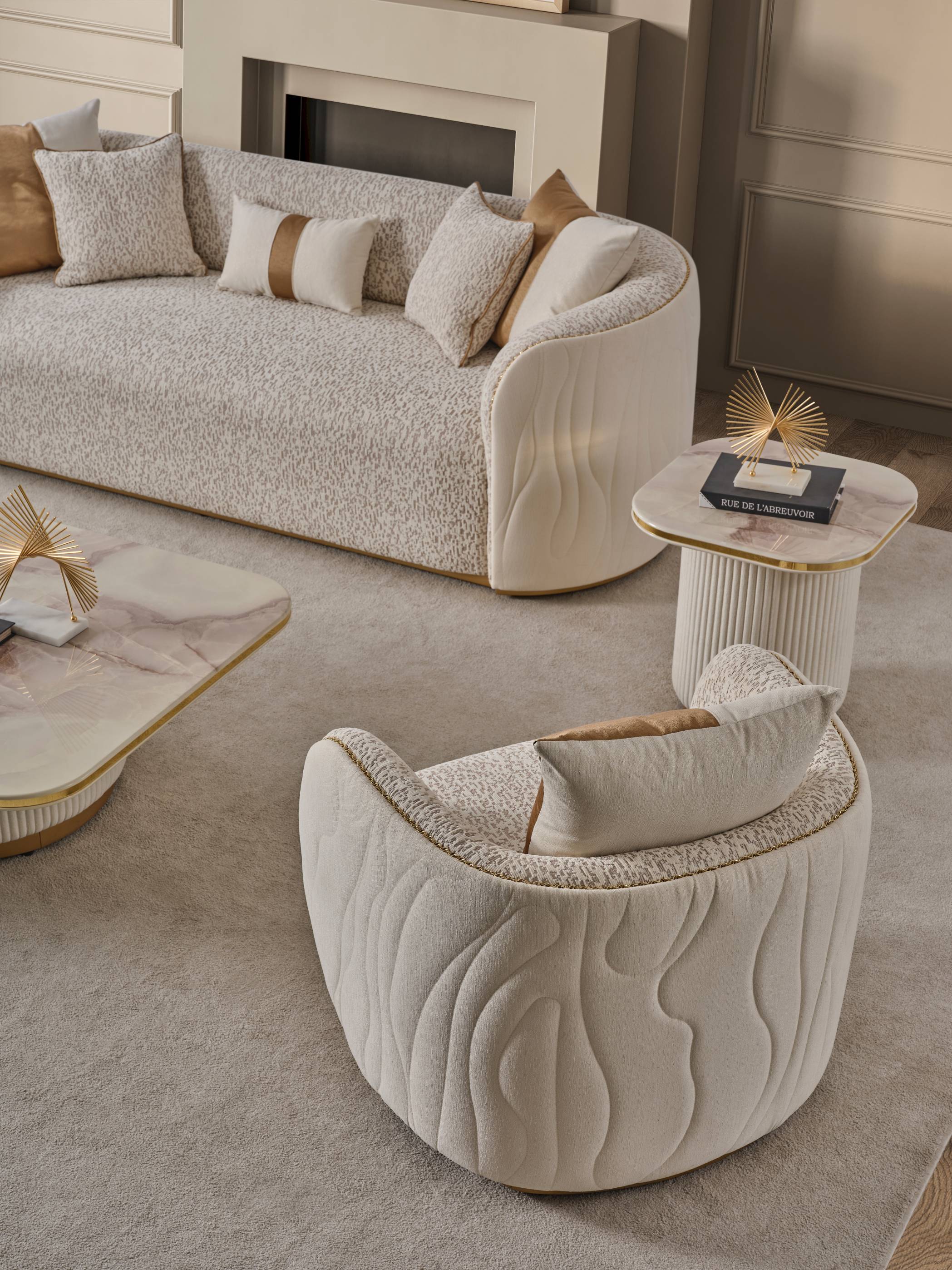 Modern living room with textured sofa and armchair, featuring decorative pillows and a side table.