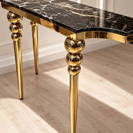 Stacked gold-tone spheres and tapered console leg.