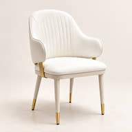 Off-white channel-back dining chair with gold-tipped legs on a neutral background.
