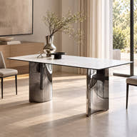 White ceramic dining table with two reflective chrome-tone pedestals styled in a room.