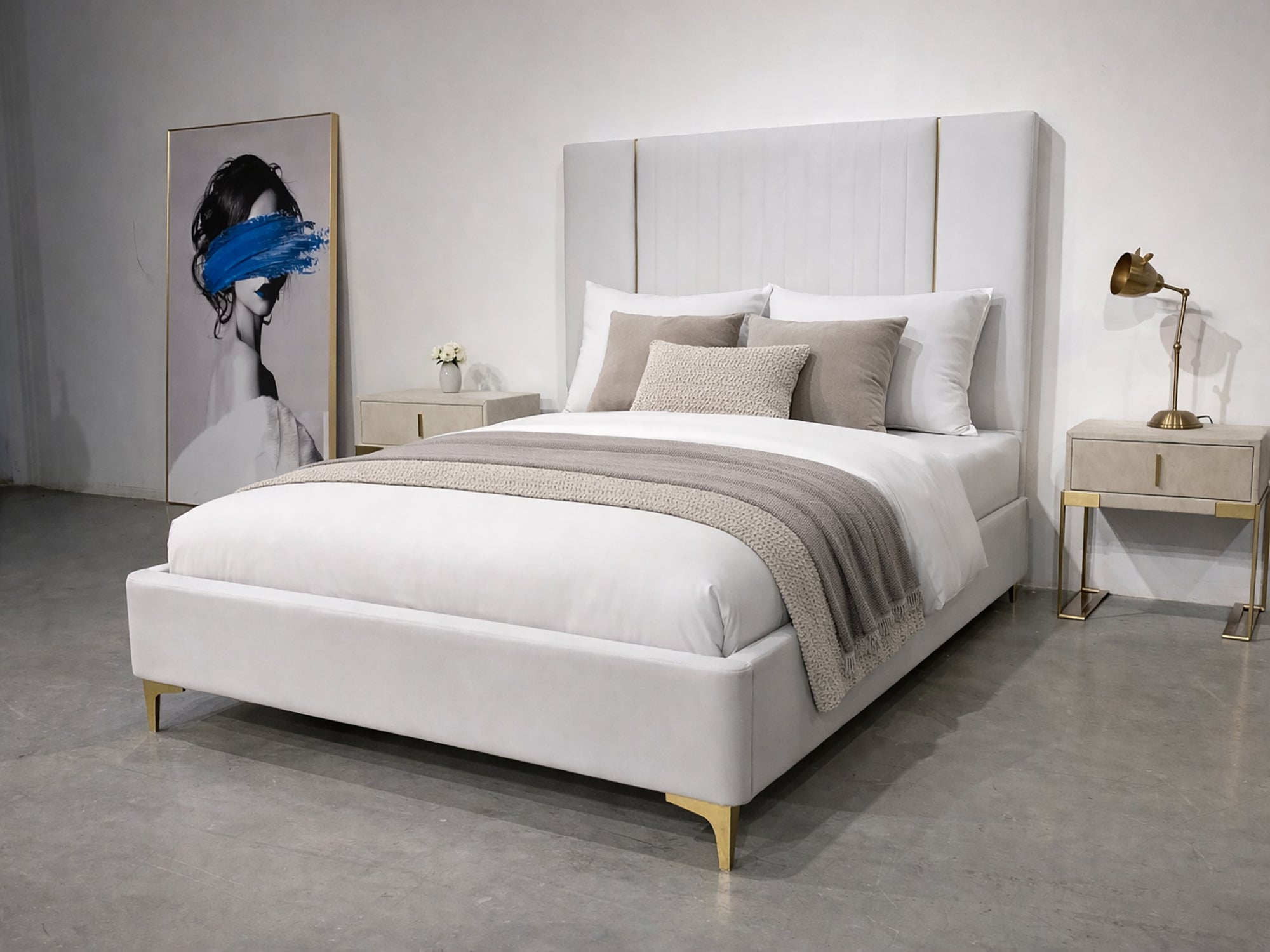 Modern bedroom with a gray upholstered bed, nightstands, and artwork on the wall.