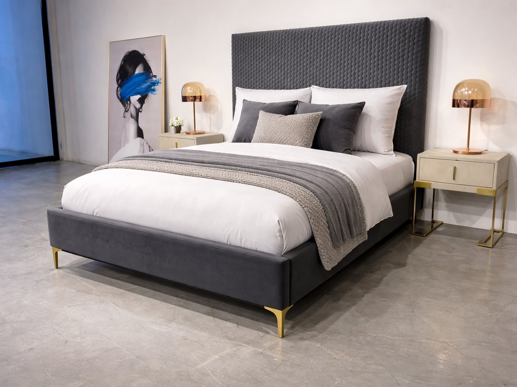 Gray upholstered bed with white bedding in a modern bedroom setting.
